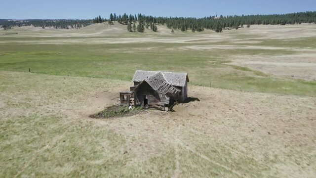Aerial: Abandoned haunted farm house on a ranch, Ukiah, Oregon, USA