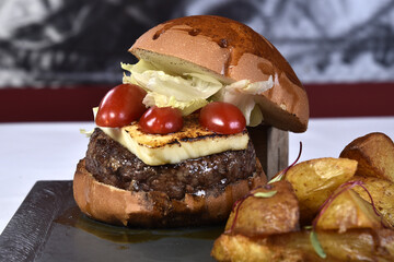 Rustic baked potato cheese tomato meat hamburger sandwich, delicious snack isolated on blurred background.