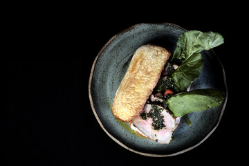Tomato cheese meat burger sandwich and vegetables, delicious snack isolated on black background, viewed from above.