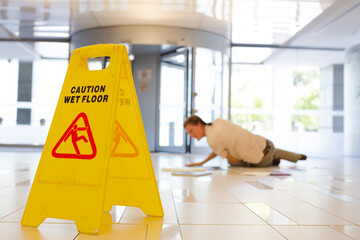 Businessman slipping on wet office floor