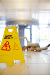 Businessman slipping on wet office floor