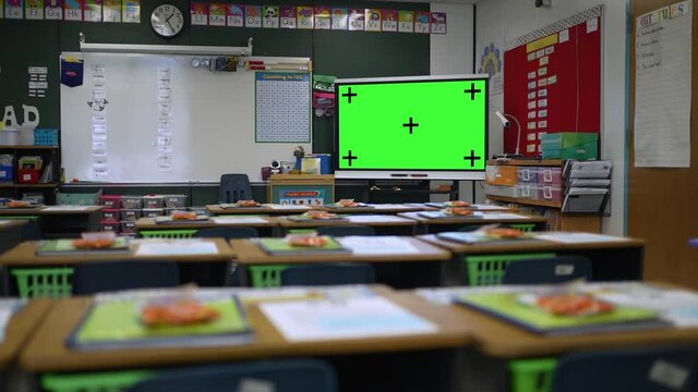 Interactive white board with green screen chroma key in empty school classroom.