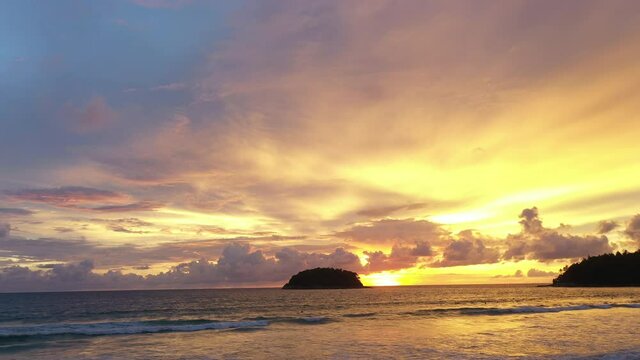 aerial view Scene of Colorful romantic sky sunset with Changing the color of the sky background. .beautiful golden sky at sunset over Pu island at Kata beach Phuket in nature and travel concept.