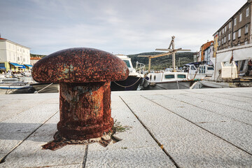 close up of a rusty metal bollard on a pier 