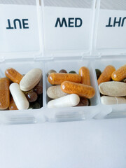 colourful pills and capsules on a pill box