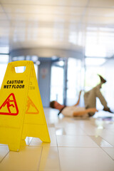 Businessman slipping on wet office floor