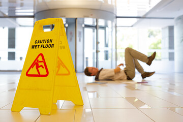 Businessman slipping on wet office floor