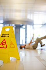 Businessman slipping on wet office floor