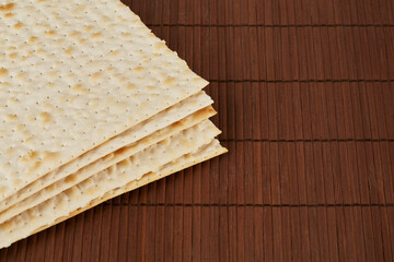 Traditional Jewish matzah lies on a wooden napkin.