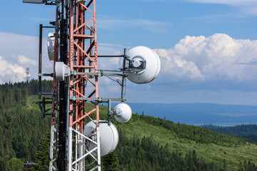 Steel broadcasting antenna tower with forest, sky and clouds in background. Eastern Slovakia near High Tatras.