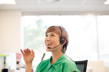 Businesswoman talking on headset at desk