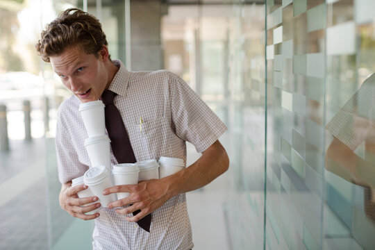 Businesswoman balancing coffee cups in office
