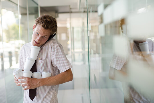 Businesswoman balancing coffee cups in office