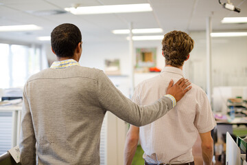 Businessman comforting colleague in office