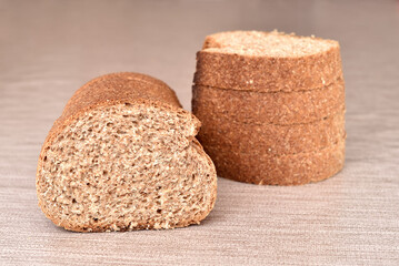 Stack of sliced fresh homemade wholegrain unleavened brown bread on the rustic wooden table
