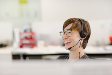 Businesswoman talking on headset at desk