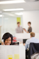Businesswoman talking on phone at desk