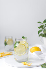 Lemon lime soda in a mason jar with a lemon slice and basil leaves, lemonade in a glass jar