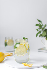 Lemon lime soda in a mason jar with a lemon slice and basil leaves, lemonade in a glass jar