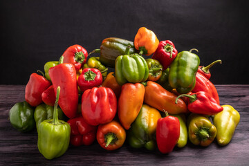 pile of yellow red and green bell peppers on dark background - Powered by Adobe