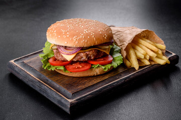 Craft beef burger and french fries on a black background