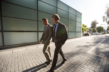 Businessmen walking on city street