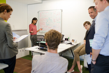 Businesswoman drawing on whiteboard in meeting