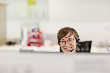 Businesswoman talking on headset at desk