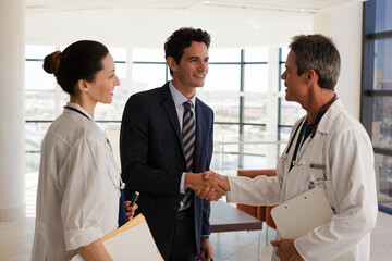 Doctor and businessman handshaking in meeting