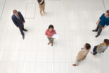 Businesswoman standing in busy office hallway