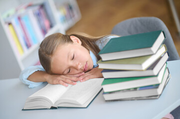 Tired pupil dozing on an open textbook