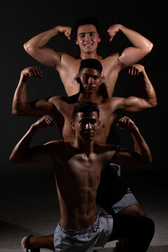 three muscular latin men posing for the camera from the biggest to the thinnest. fitness concept