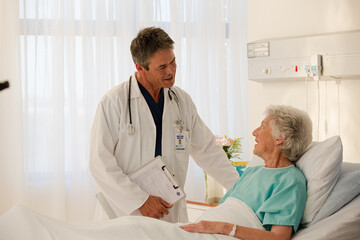 Doctor and senior patient talking in hospital room