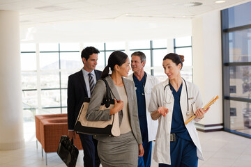 Doctor carrying folders in hospital