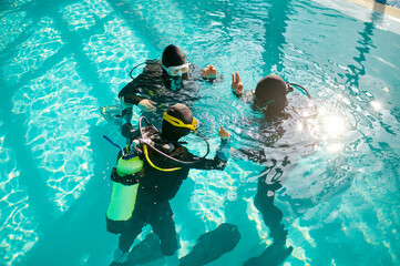 Divemaster and divers in aqualungs, diving school