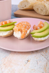 Avocado and shrimp sandwiches on a pink plate