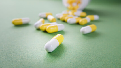 The pills are scattered on the table. Tablets on the green background. Medicinal tablets, capsules.