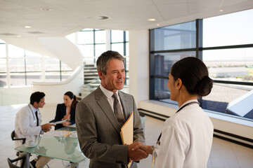 Nurse and aging patient talking in hospital room