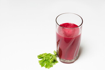 red beet juice in a glass cup with celery leaf on white background, healthy eating environment

