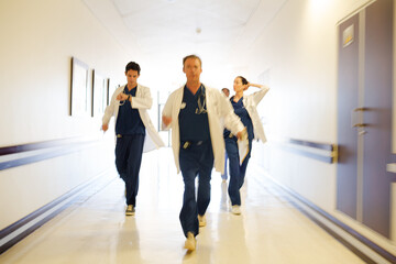 Fototapeta premium Doctors rushing down hospital corridor