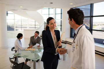 Doctor and businesswoman handshaking in meeting - Powered by Adobe