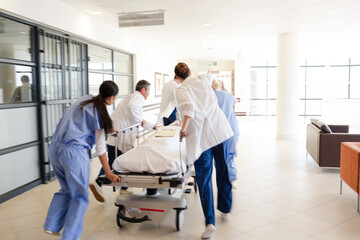 Obraz premium Doctors rushing patient on gurney in hospital corridor