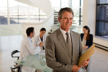 Portrait of smiling businessman in meeting with doctors