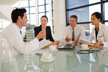 Portrait of smiling doctors and nurse in hospital corridor