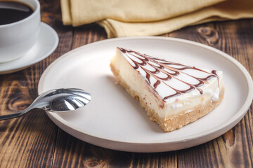 Cheesecake on a white plate with a coffee.