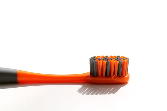 Gray orange toothbrush with a shadow on a white background