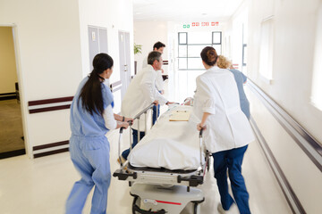 Doctors rushing patient on gurney in hospital corridor