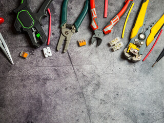 various electrician tools on gray background with copy space. view from above