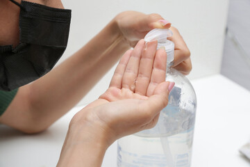 passando álcool com gel na mão para se proteger do covid19.
