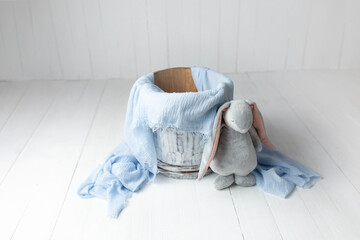wooden basket for a photo shoot of a newborn baby with blue decor and a plush hare toy. furniture...